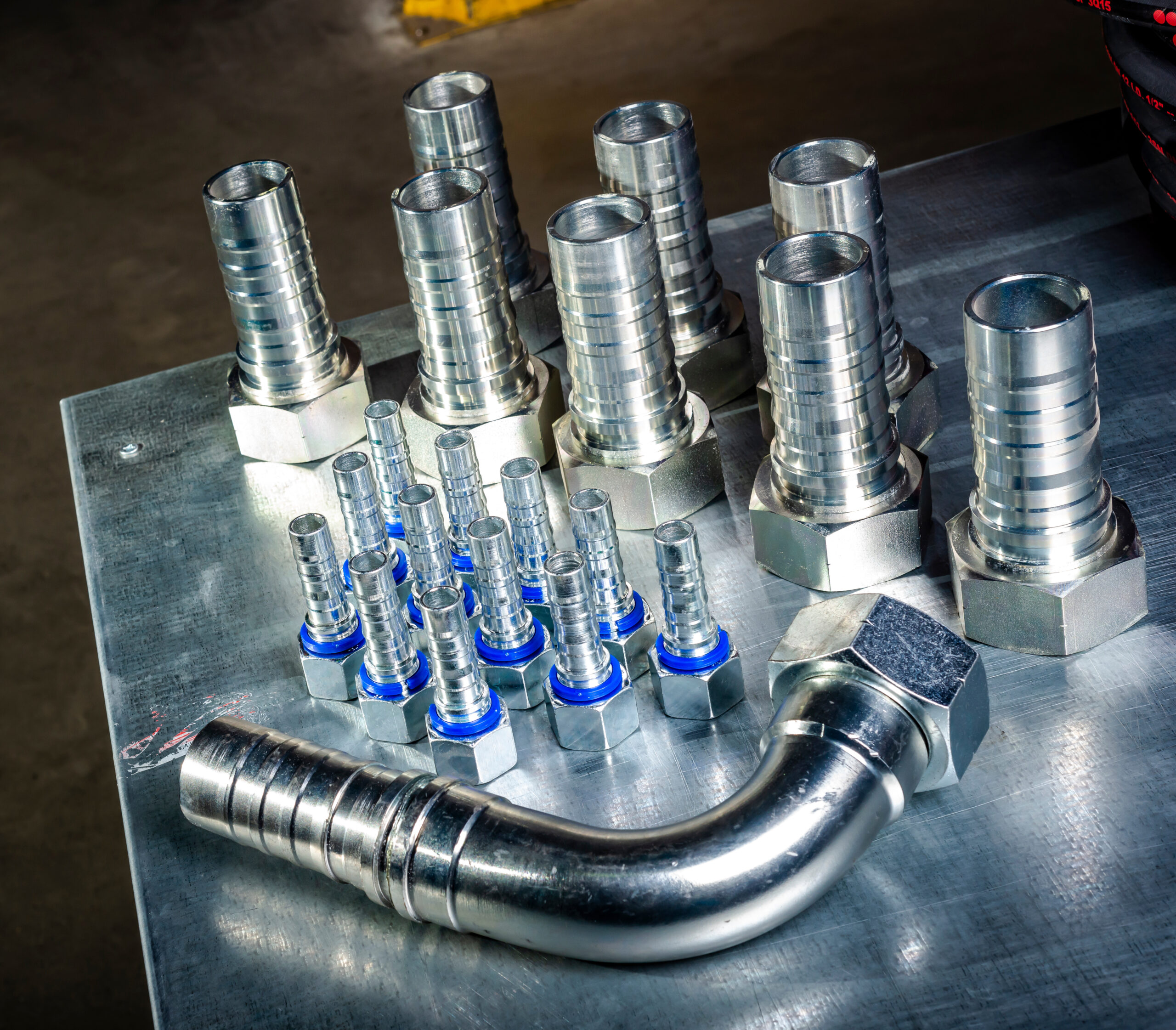 Metal hydraulic fittings stands on the silver table in the warehouse